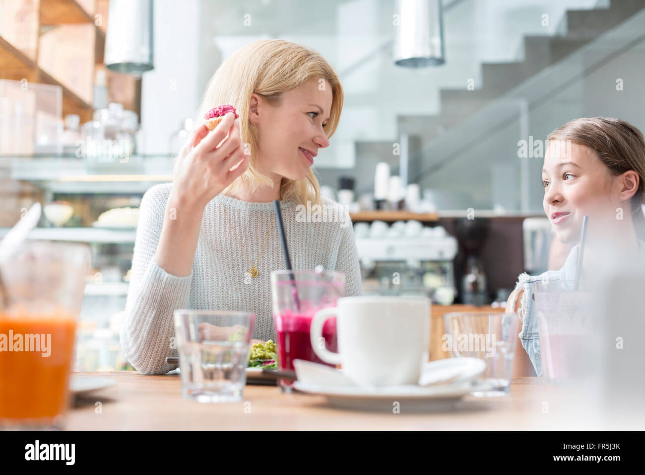 Mother and daughter eating at cafe table Stock Photo