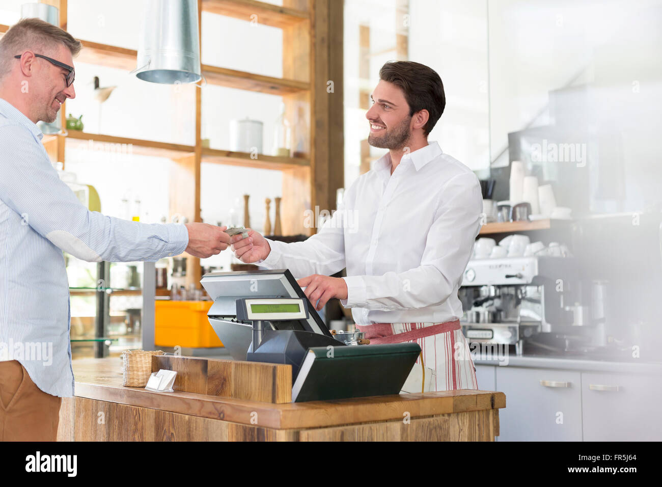 Customer paying worker at cafe cash register Stock Photo