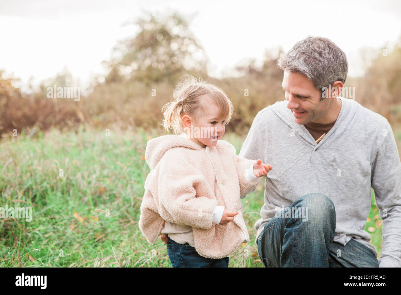 Father and toddler daughter in autumn park Stock Photo