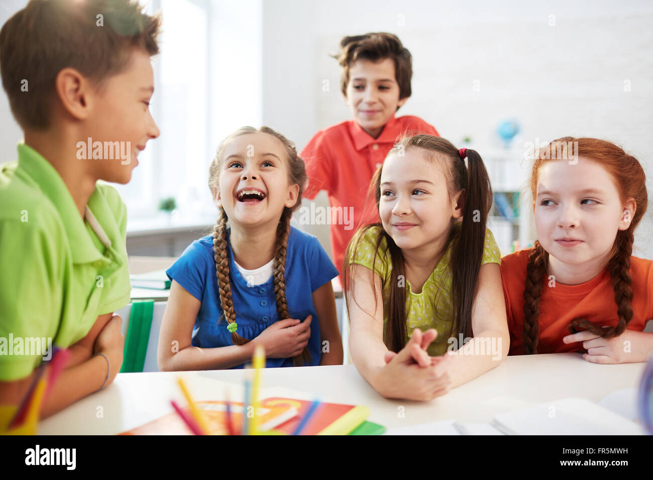 Elementary students talking together at the table Stock Photo Alamy