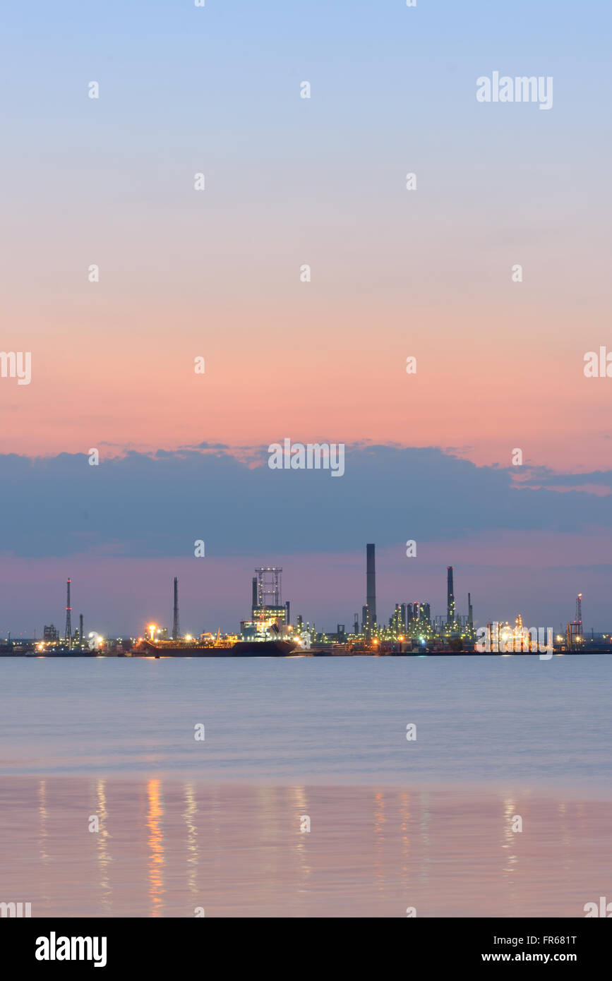 Petrochemical  refinery at sea at sunset Stock Photo