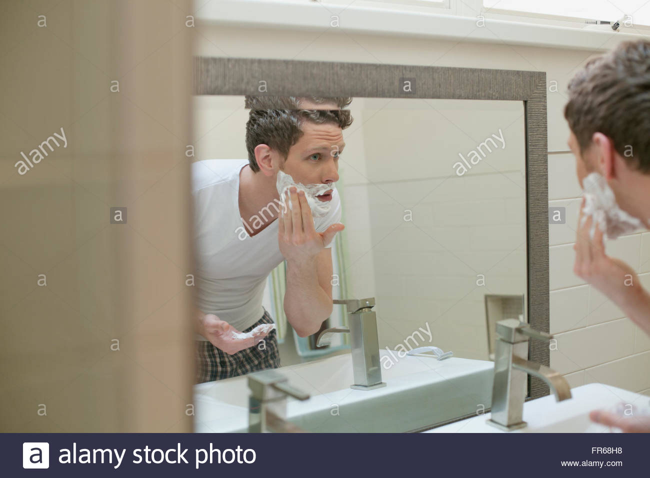 man shaving in bathroom Stock Photo Alamy