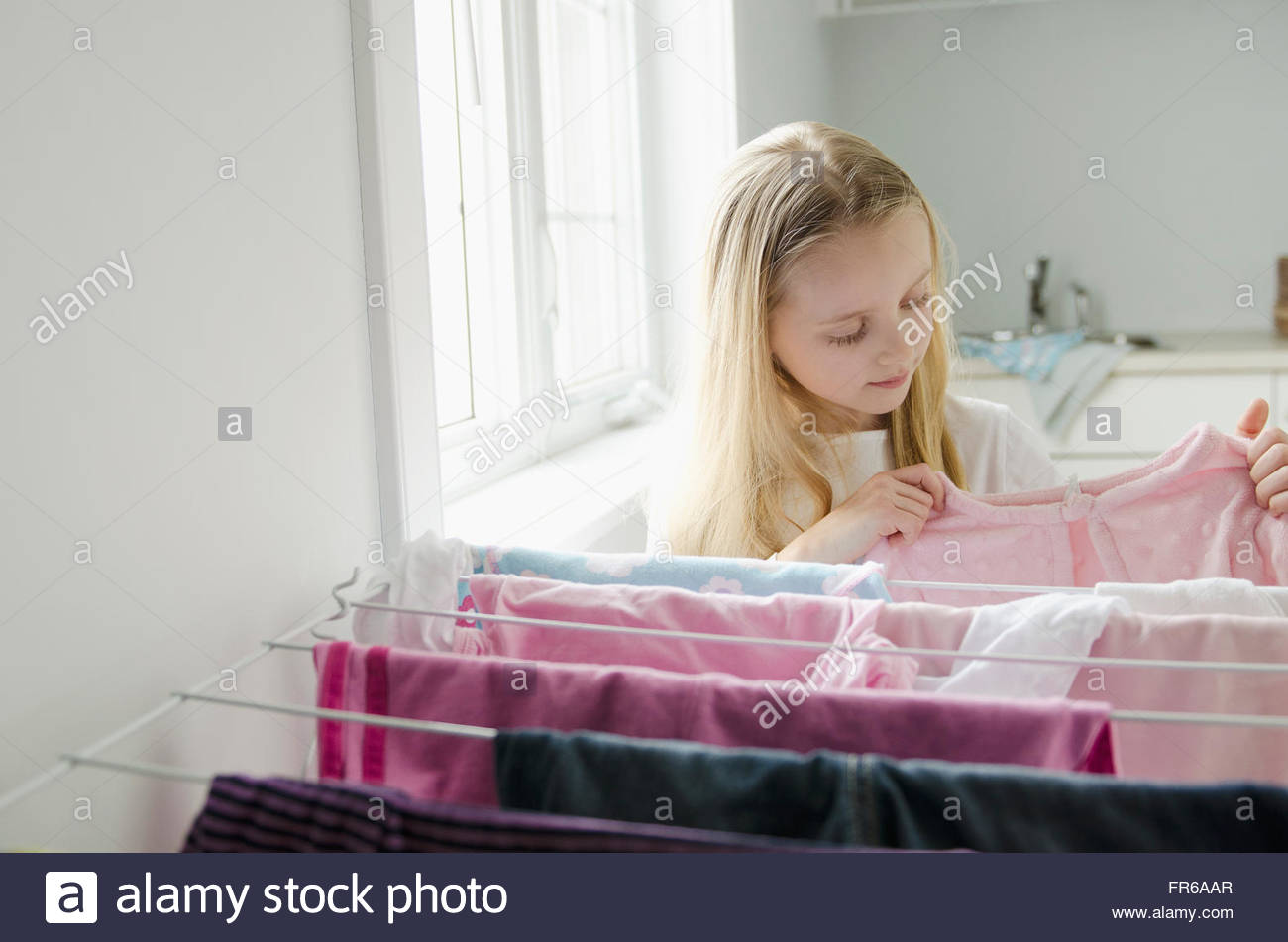 young girl helping with laundry chores Stock Photo Alamy