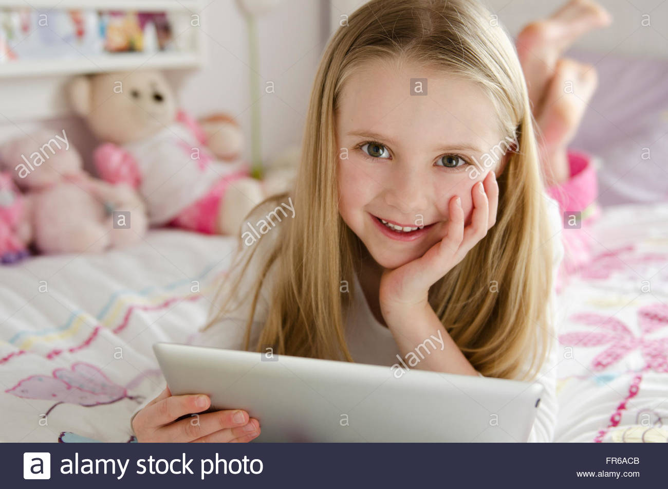 young girl playing on ipad in bedroom Stock Photo Alamy