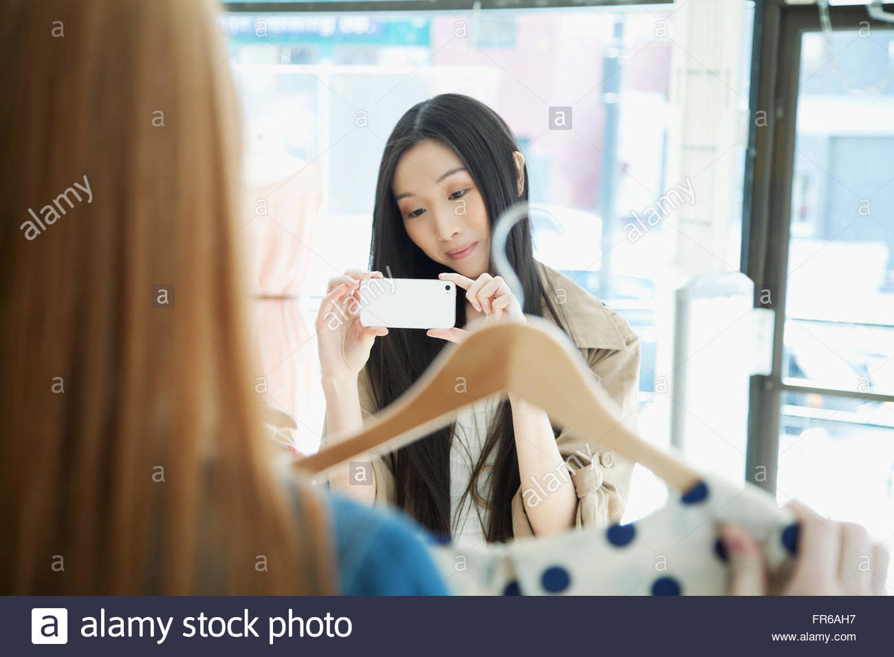 girlfriend taking picture in clothing store Stock Photo - Alamy