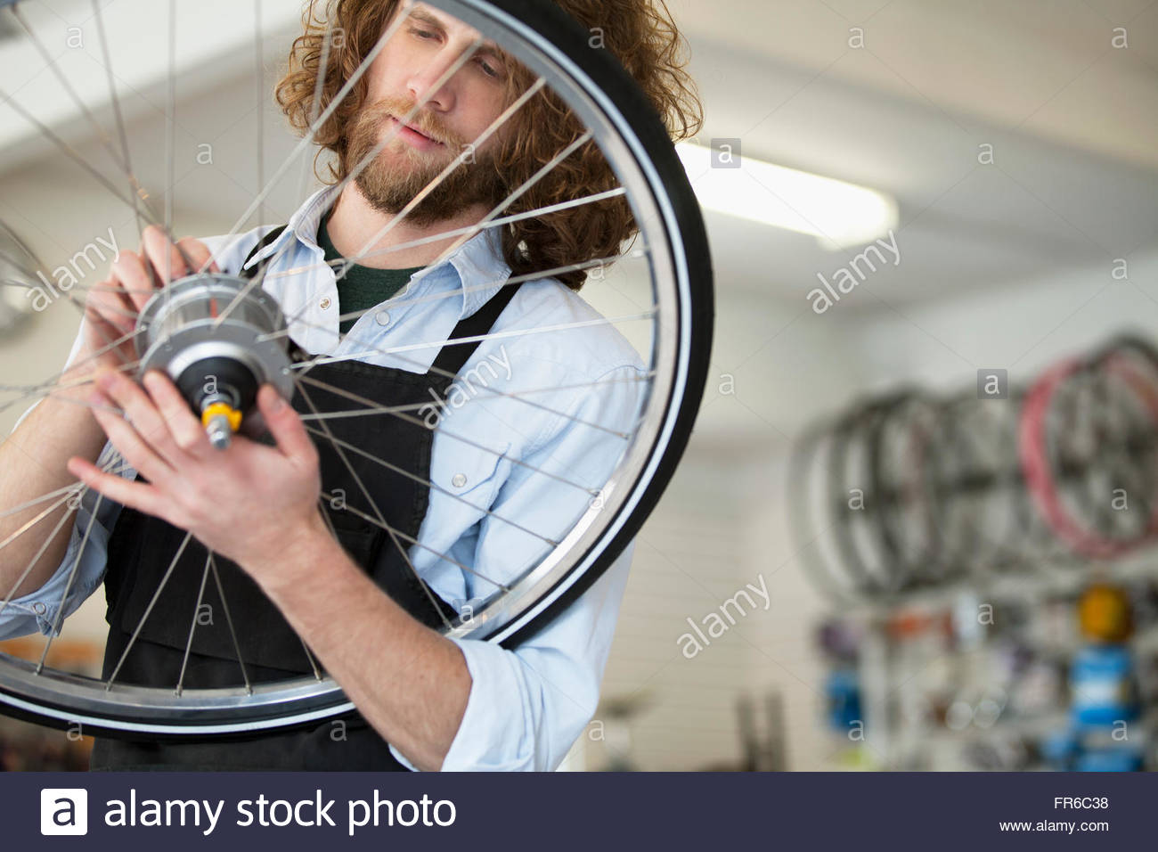 bike shop owner repairing spokes Stock Photo Alamy