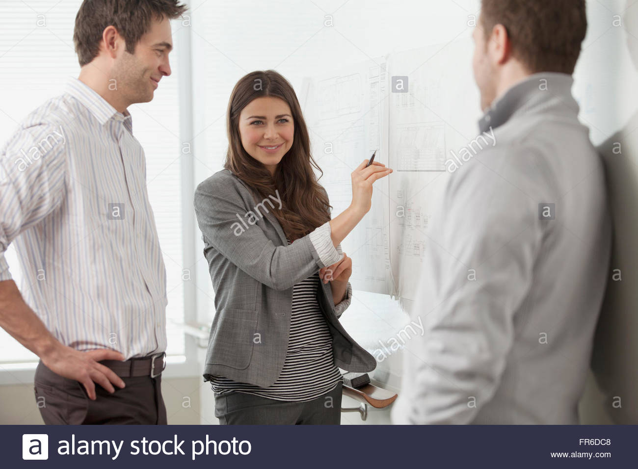 coworkers discussing at whiteboard Stock Photo