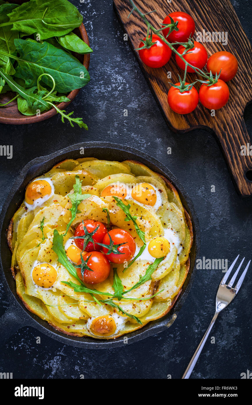 Breakfast potato frittata with spinach, cherry tomatoes and cheese in