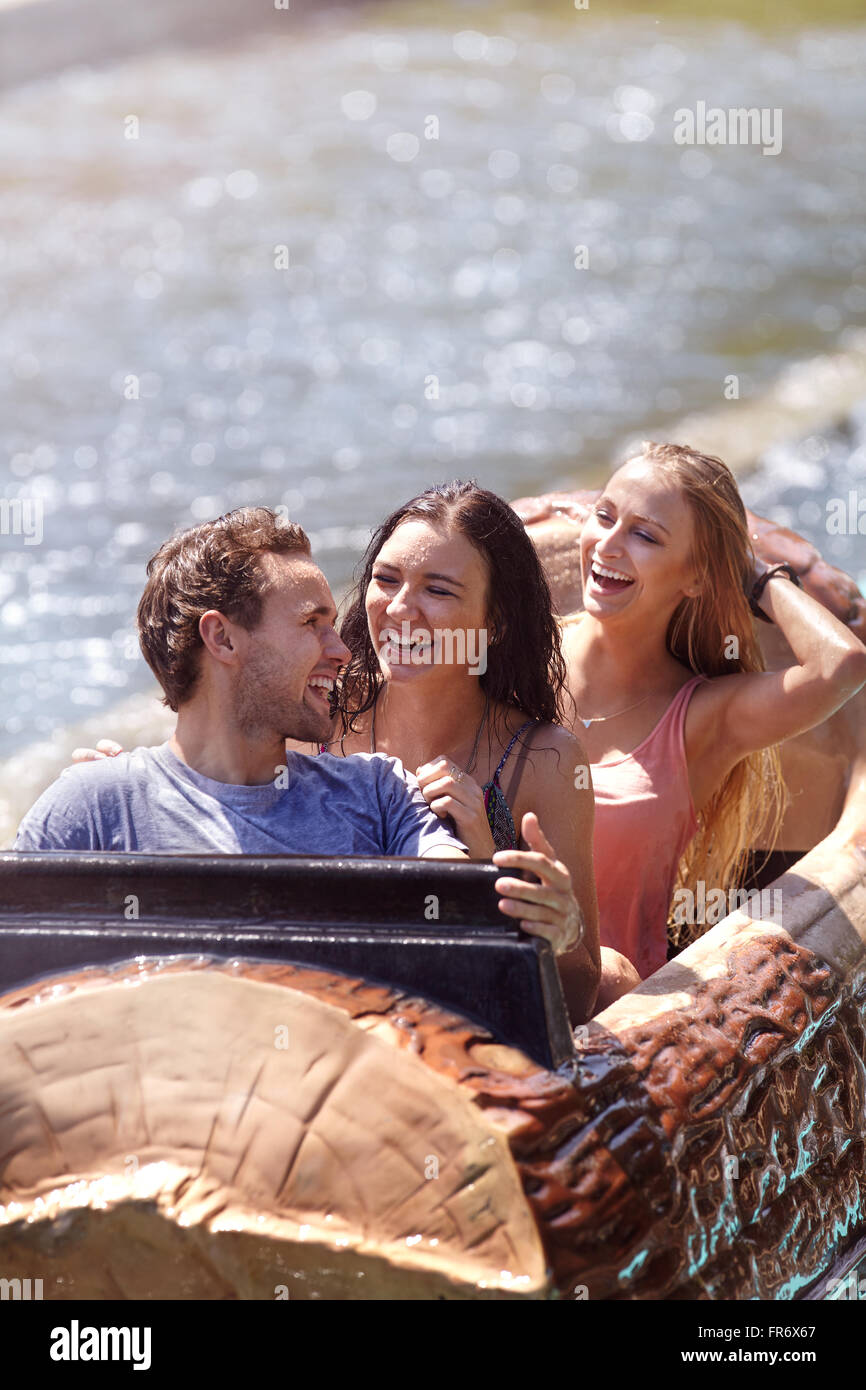 Wet friends laughing on log amusement park ride Stock Photo