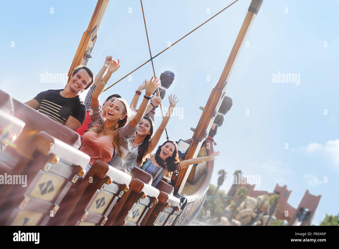 Friends cheering on amusement park ride Stock Photo