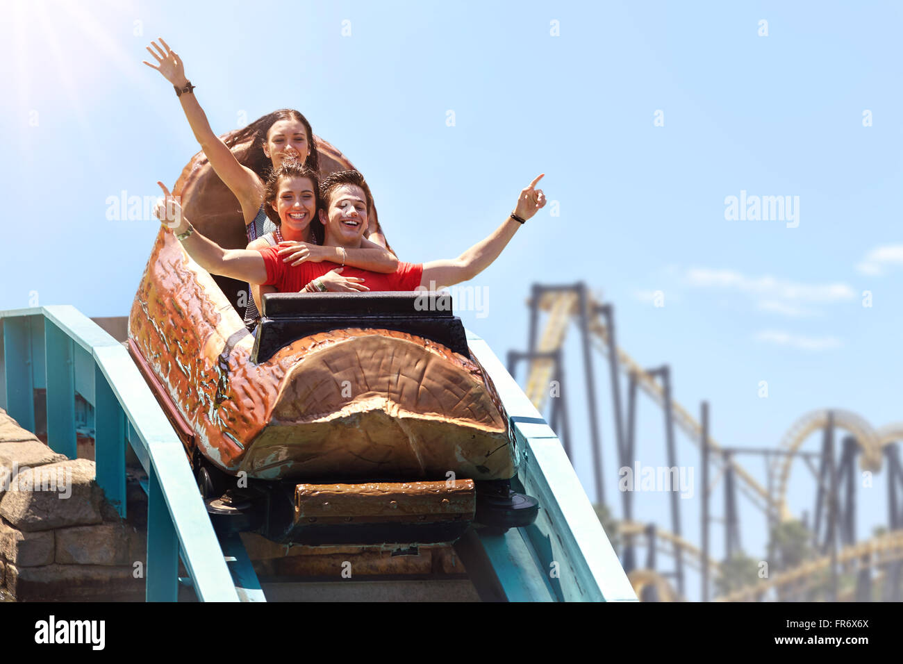 Friends cheering and riding log amusement park ride Stock Photo