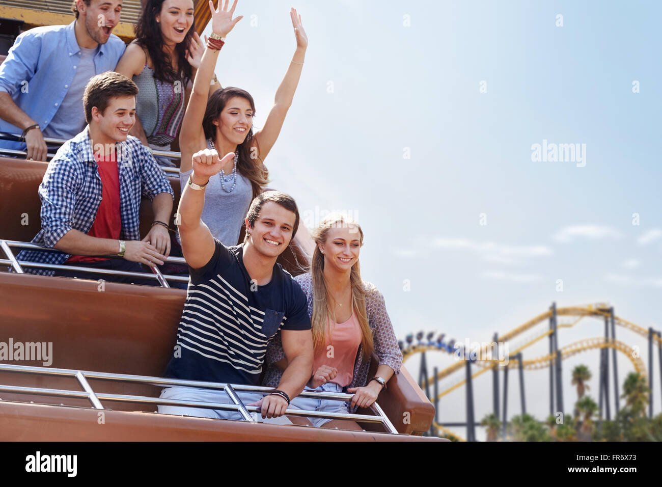 Portrait young man giving thumbs-up on amusement park ride Stock Photo