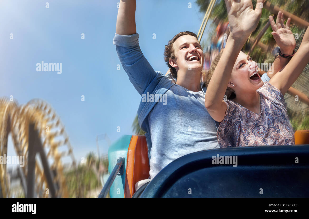 Enthusiastic couple cheering and riding amusement park ride Stock Photo