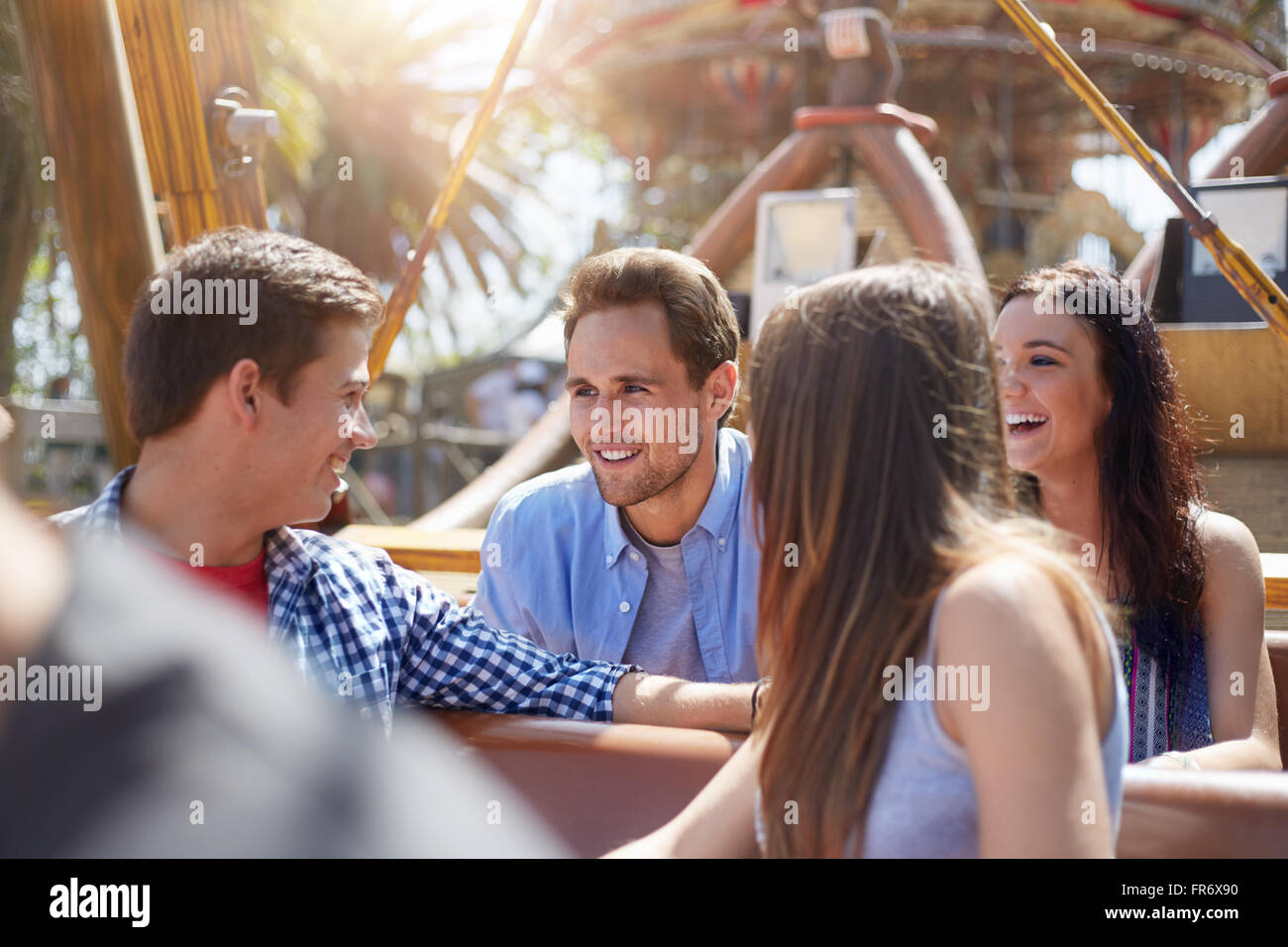 Smiling friends talking on amusement park ride Stock Photo