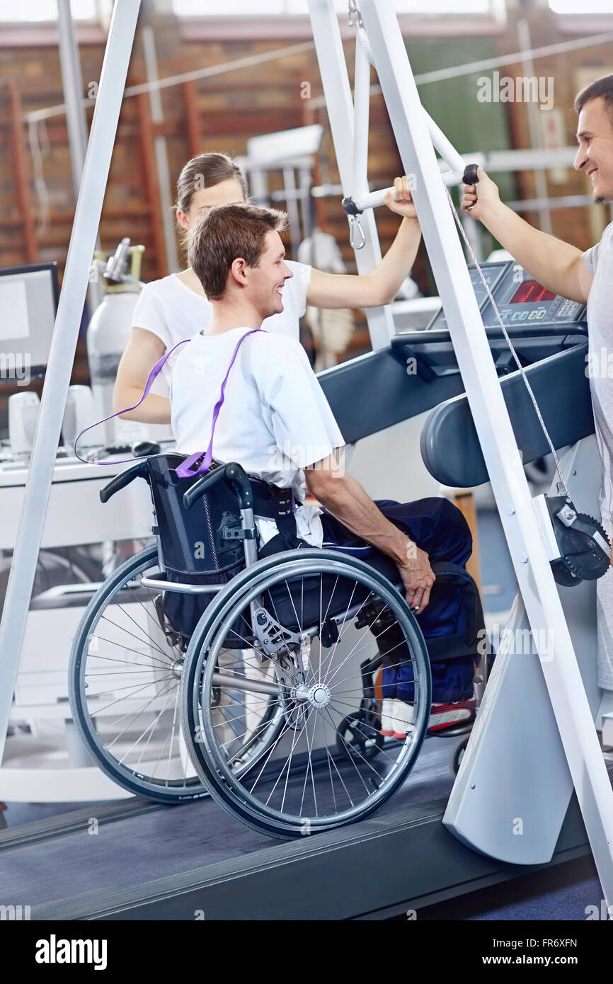 Physical therapists guiding man in wheelchair on treadmill Stock Photo -  Alamy