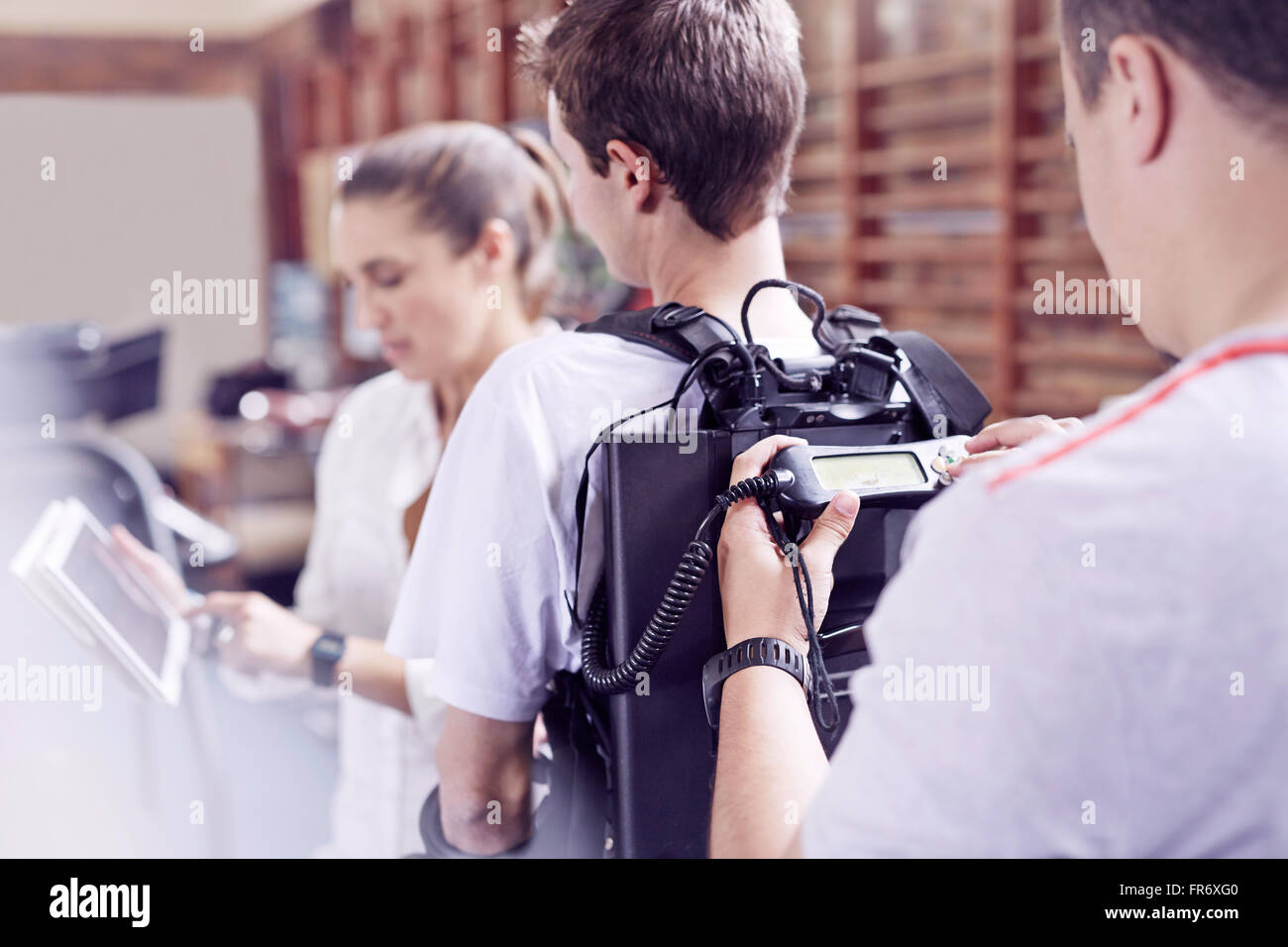 Physical therapist checking equipment monitor on man’s back Stock Photo