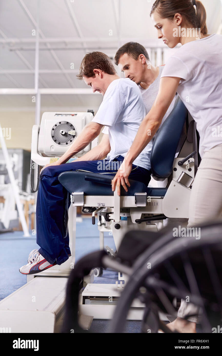 Physical therapists guiding man using equipment Stock Photo Alamy