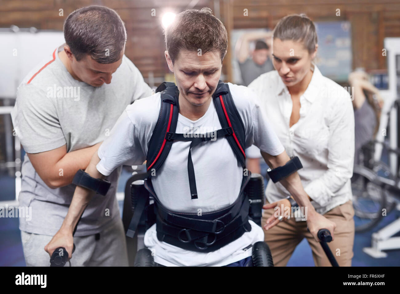 Physical therapists guiding man walking Stock Photo