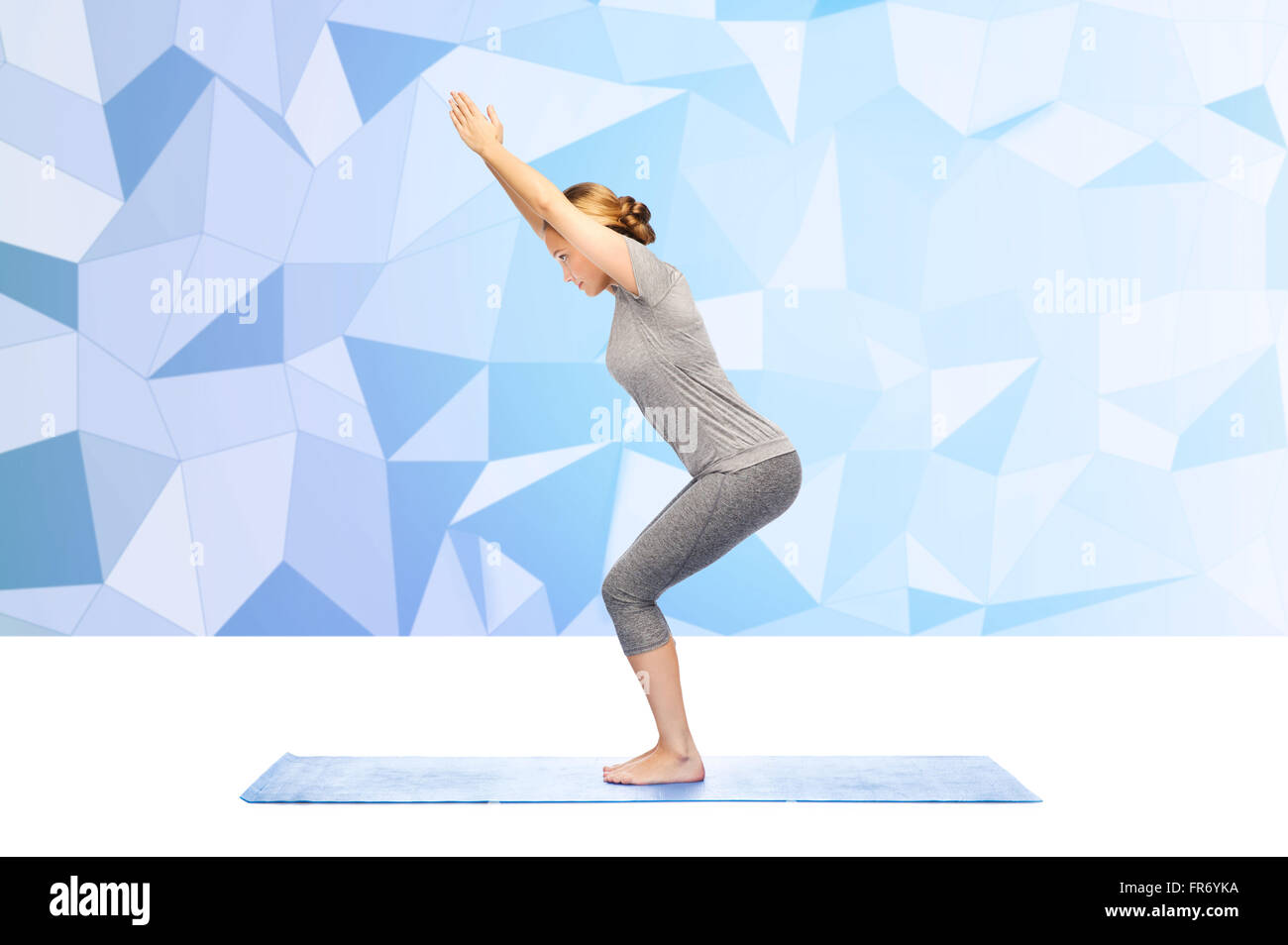 woman making yoga in chair pose on mat Stock Photo - Alamy