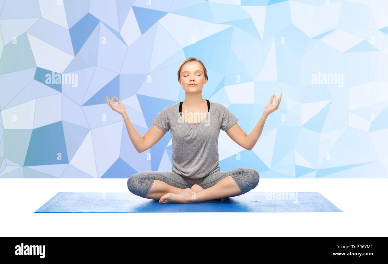 woman making yoga meditation in lotus pose on mat Stock Photo - Alamy