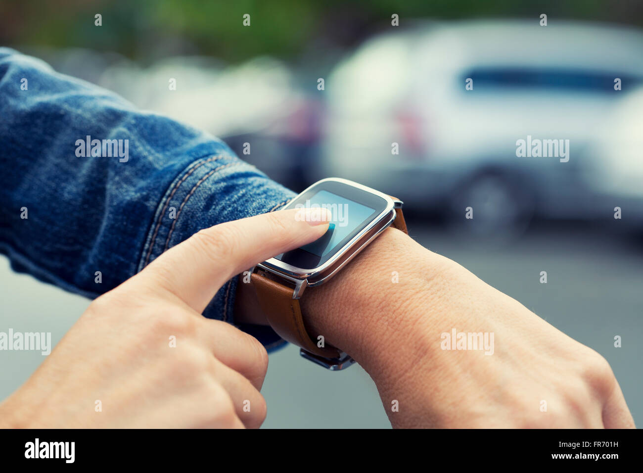 Woman looking for her car with smartwatch in parking car Stock Photo