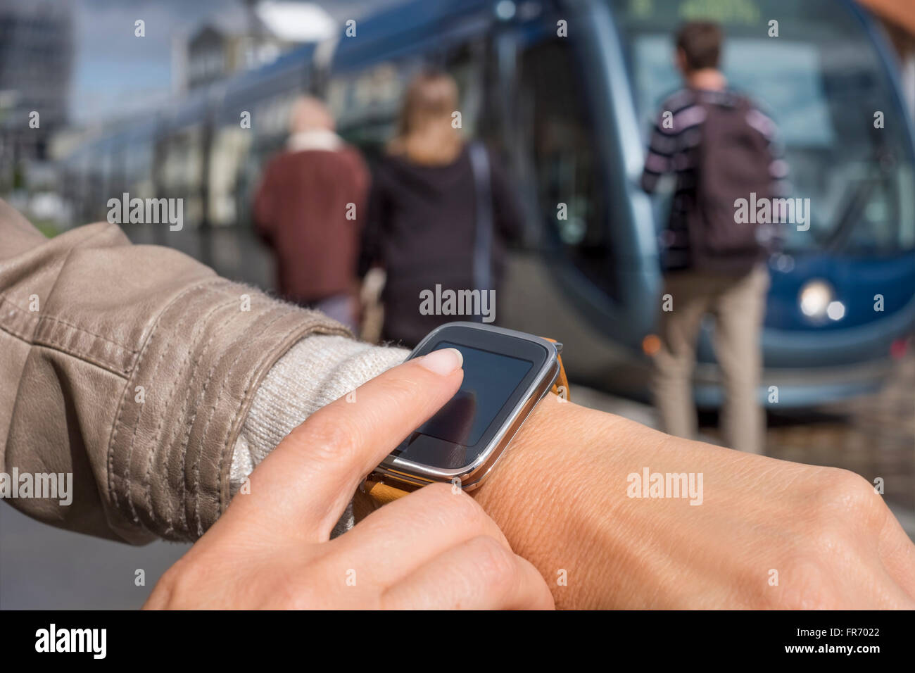 Female using her smartwatch on platform station tramway Stock Photo