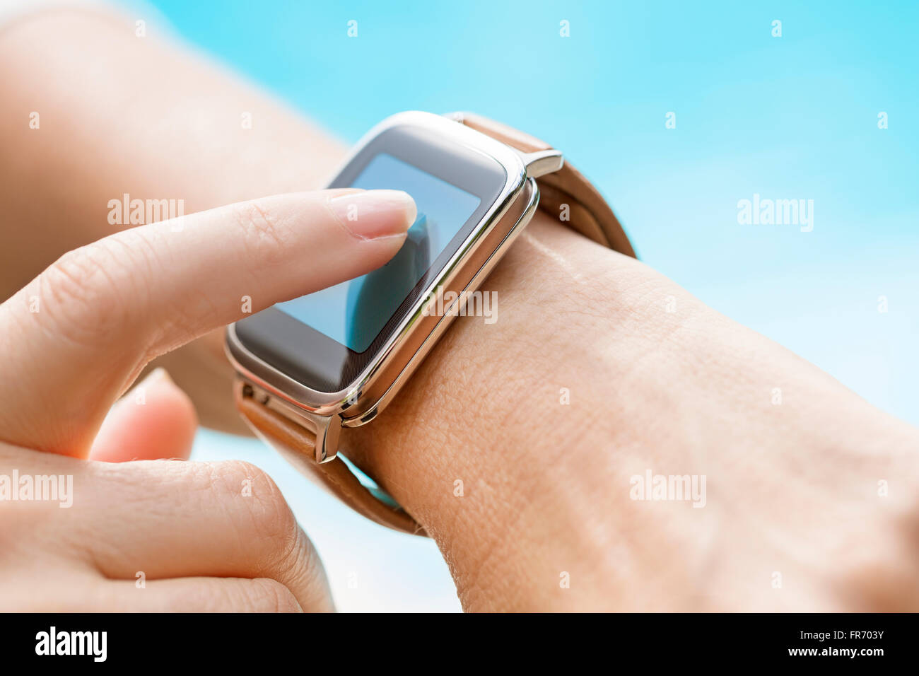 By the pool a woman using her smartwatch Stock Photo