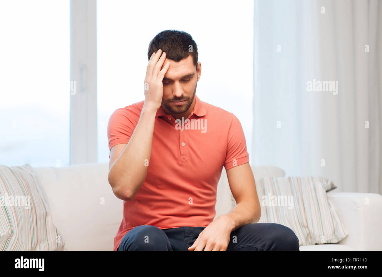 unhappy man suffering from headache at home Stock Photo - Alamy