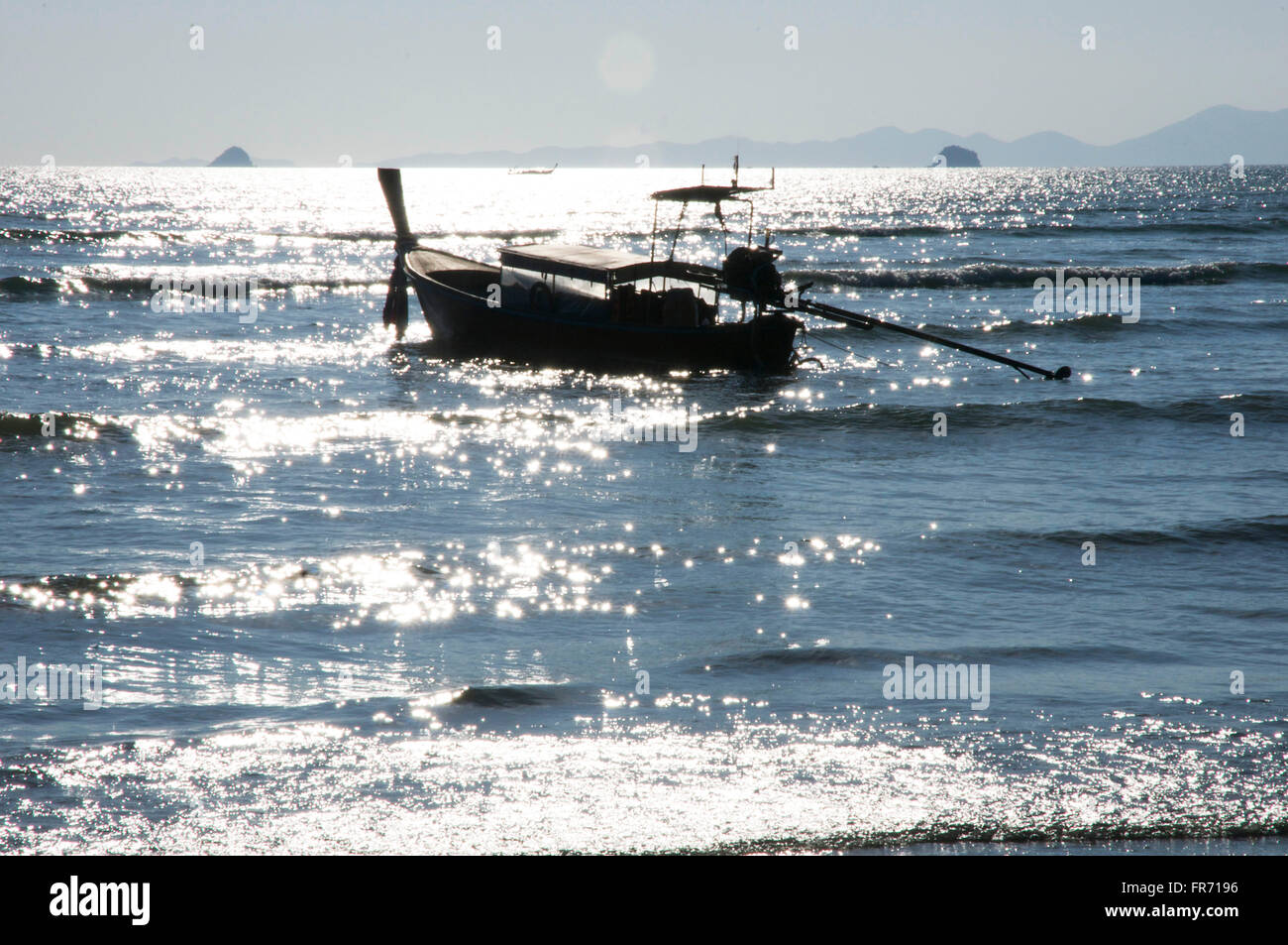 silhouette of longtail boat in sparkling water off Ao Nang beach Stock Photo