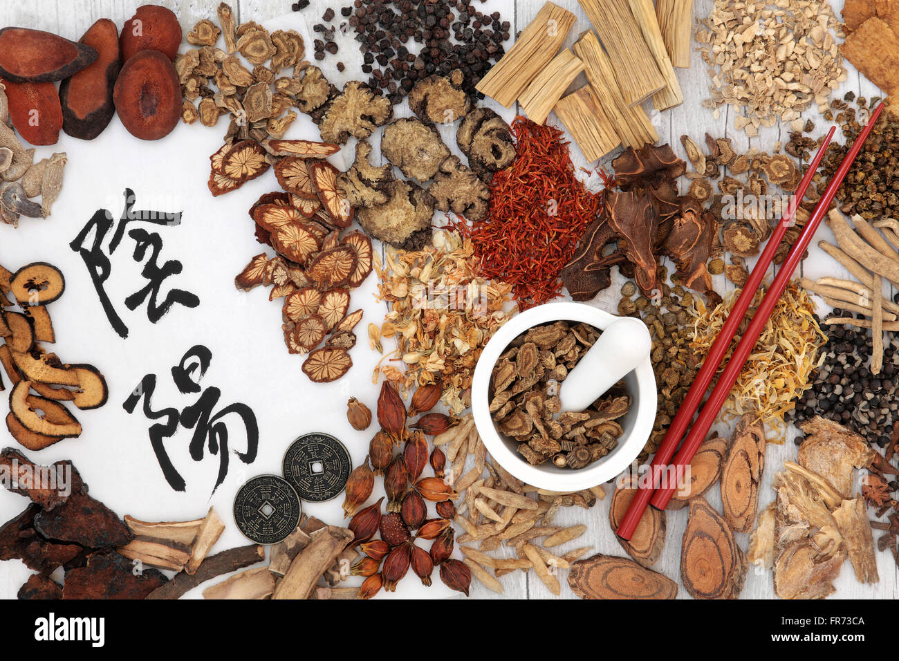 Yin and yang symbols with traditional chinese herbal medicine selection, i ching coins, mortar with pestle and chopsticks. Stock Photo