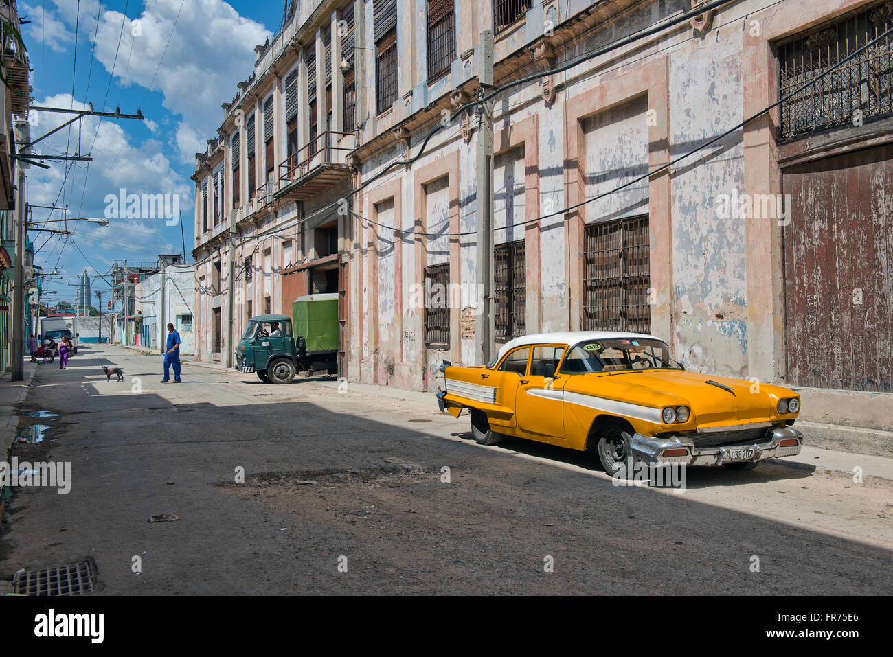 A vintage yellow car parked on the streets of Havana, Cuba. Many of these old cars are used as taxis today. Stock Photo