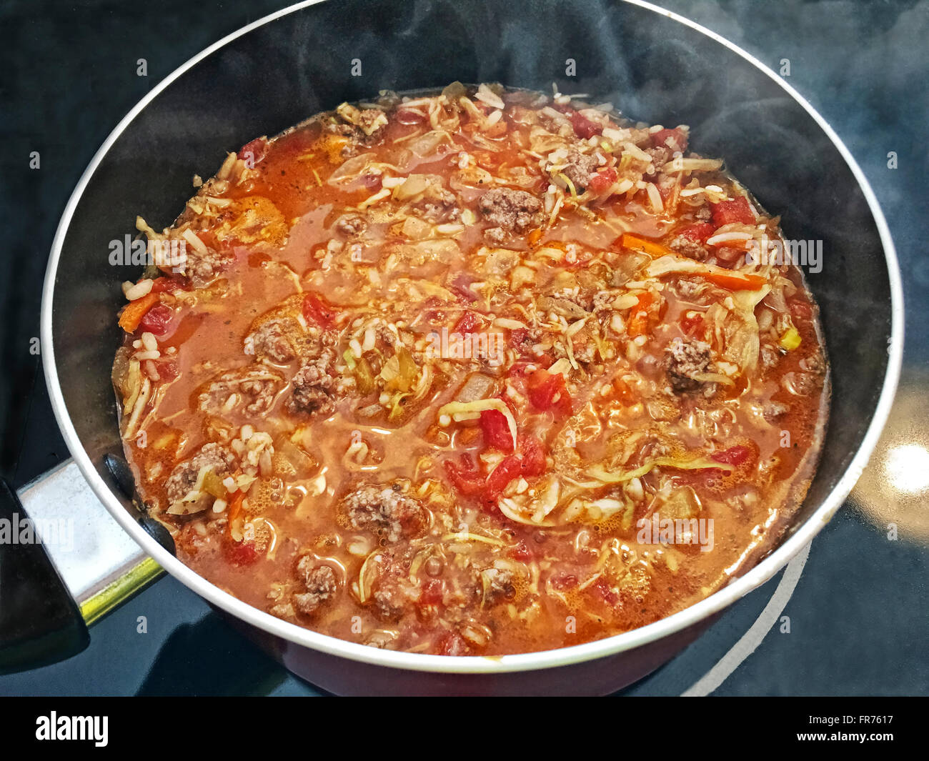Goulash cooking on the stove top with steam rising from the pot. Stock Photo