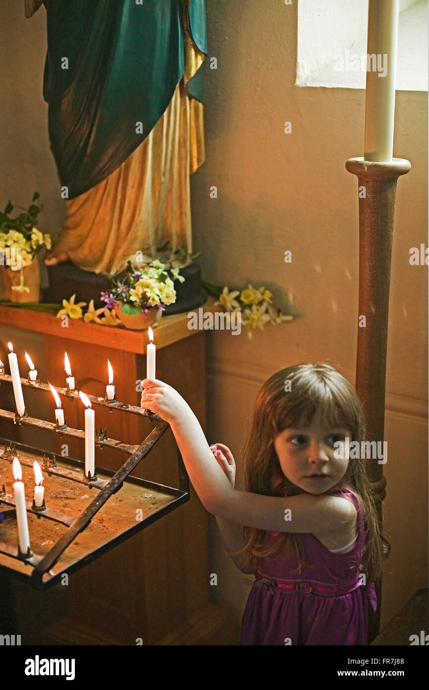 child lighting candle in church Stock Photo - Alamy