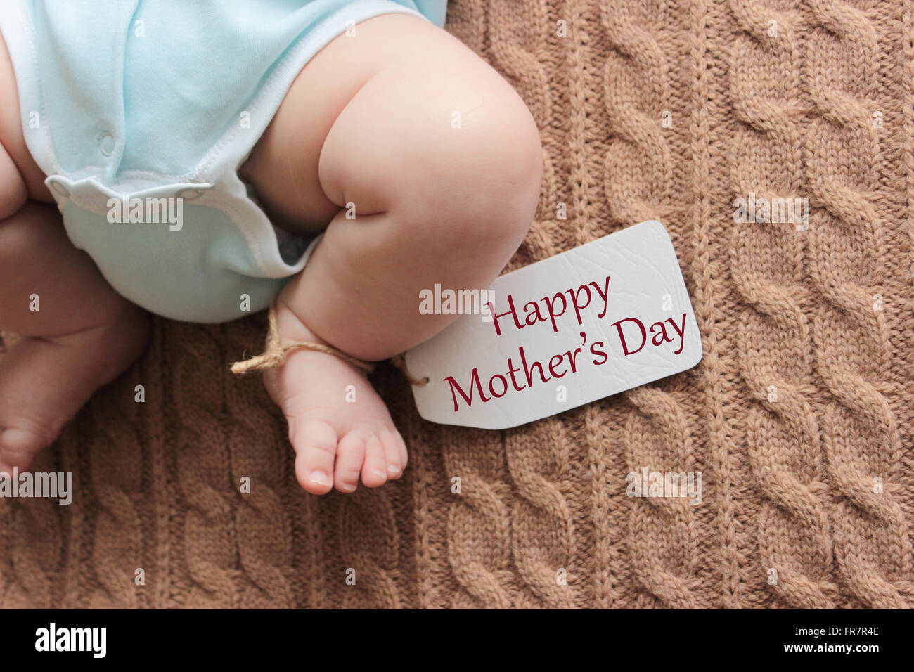 Newborn baby feet on knitted background, mother's day concept Stock Photo