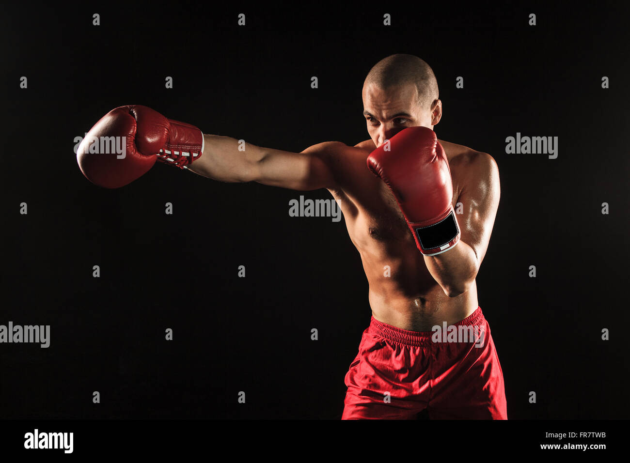The young man kickboxing on black Stock Photo - Alamy
