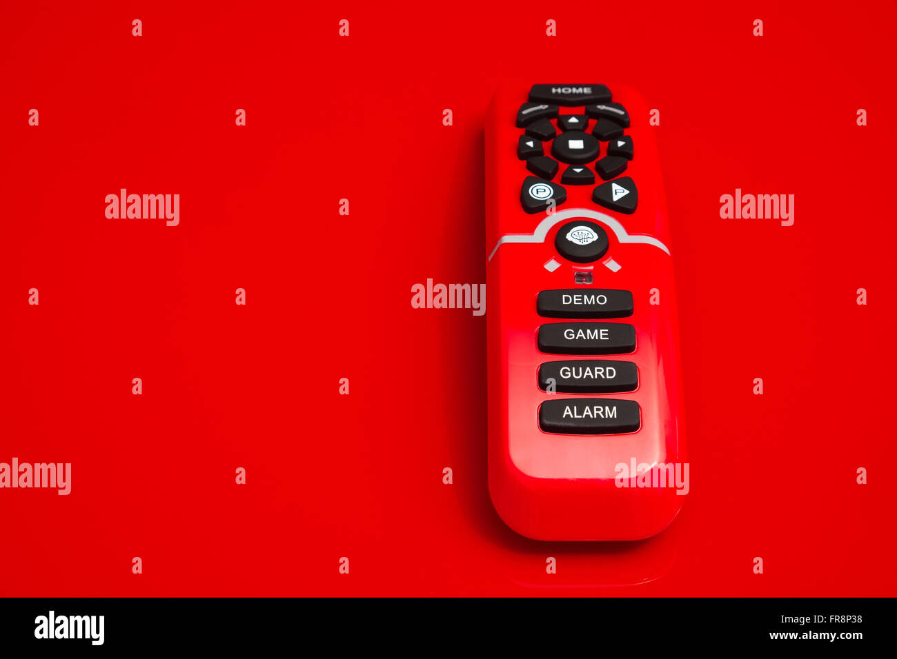 remote control with black rubber buttons with the text demo, game, guard and alarm printed on Stock Photo