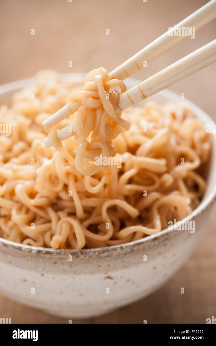 Ramen noodles in a traditional Japanese ceramic bowl with chopsticks shot with shallow focus Stock Photo