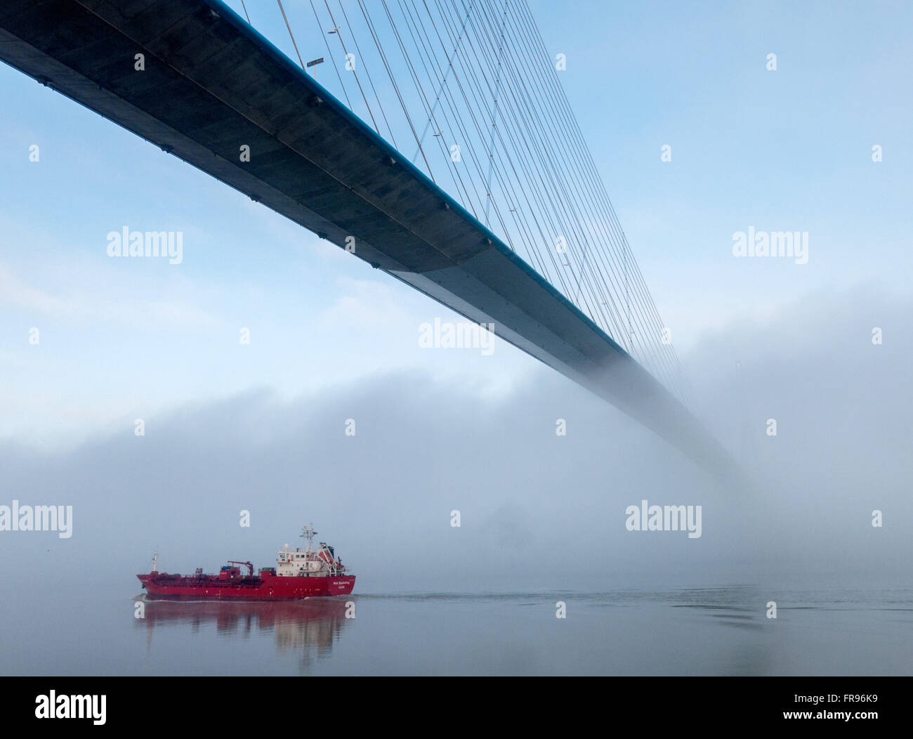 Outbound tanker passes under the Pont de Normandie, heading out to sea Stock Photo