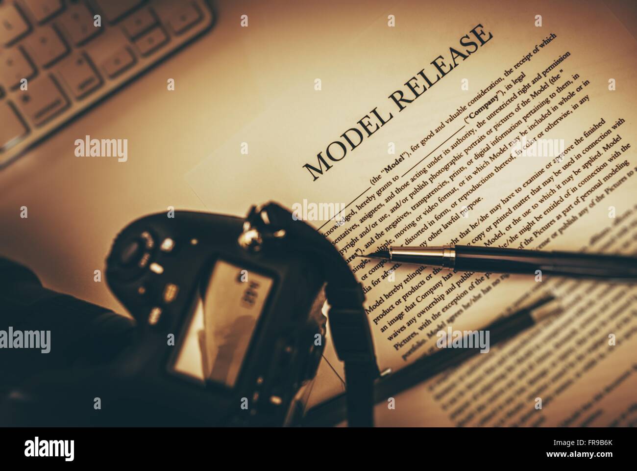 Model Release Documents with Elegant Pen and Part of Camera. Photography Business Legal Concept. Stock Photo