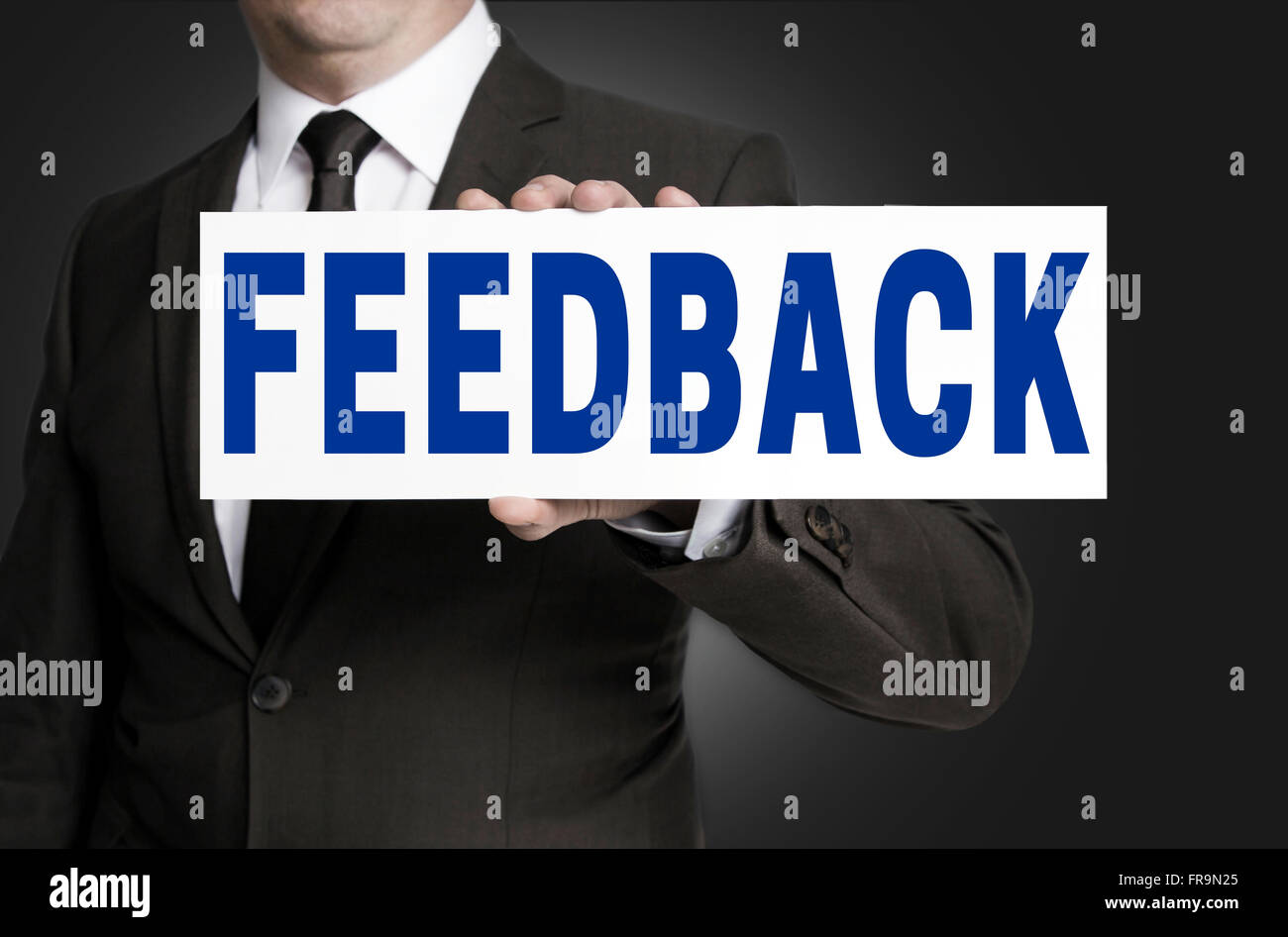 feedback sign is held by businessman background. Stock Photo