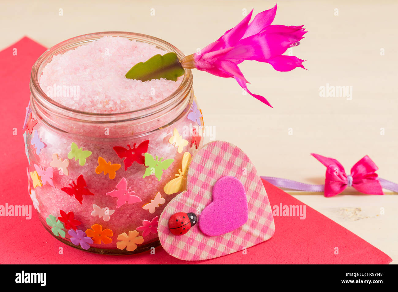 glass jar with colorful butterfly stickers filled with bathing salt Stock Photo