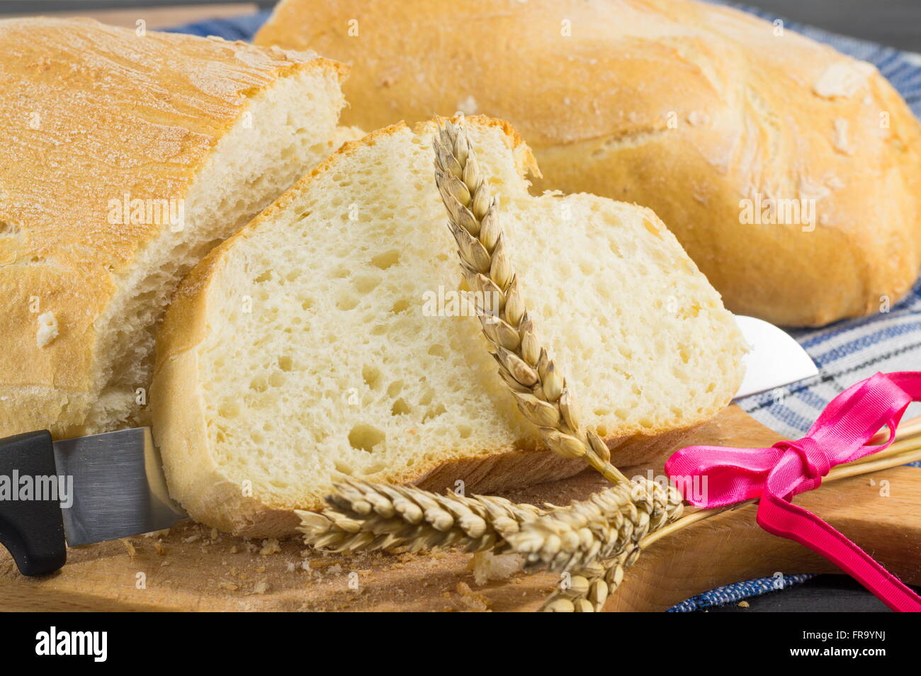 Home baked bread and a knife on the table Stock Photo