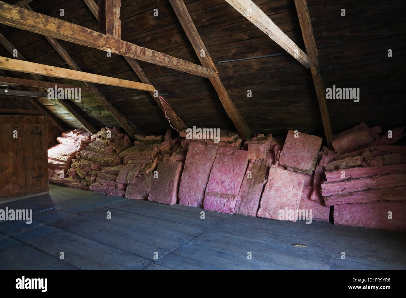 Wooden Floor Beams And Roof Boards With Stacked Pink Fiberglass