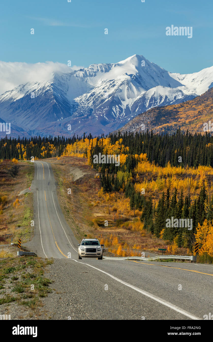 Car Drives On The Alaska Highway With Snow Capped Peaks Of The St