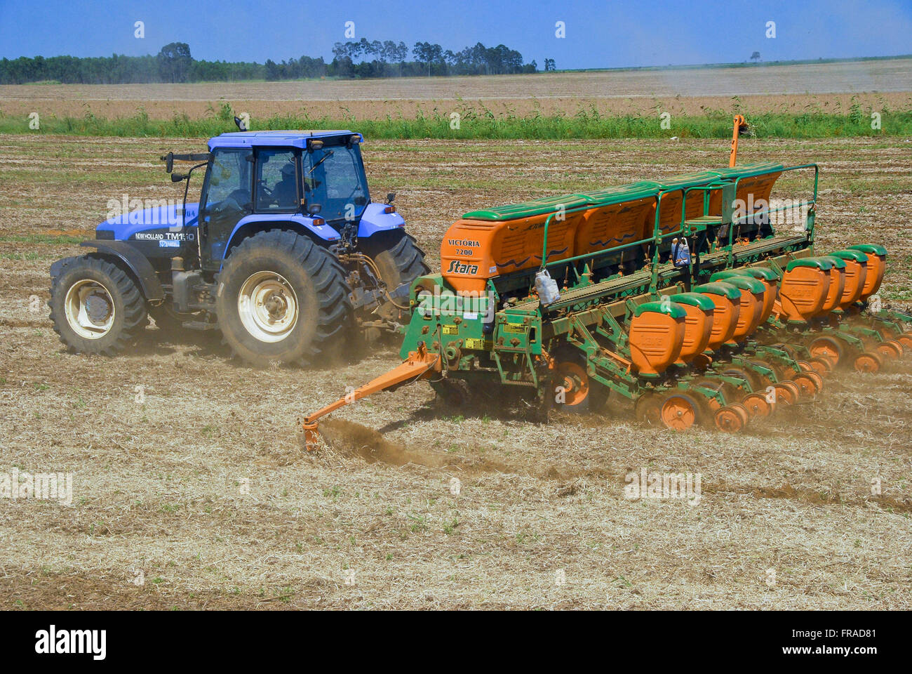 Tractor with planter performing planting grain in the countryside Stock Photo