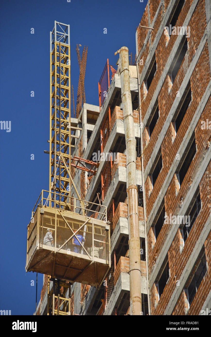 Residential building construction - Detail of the external elevator carrying workmen Stock Photo