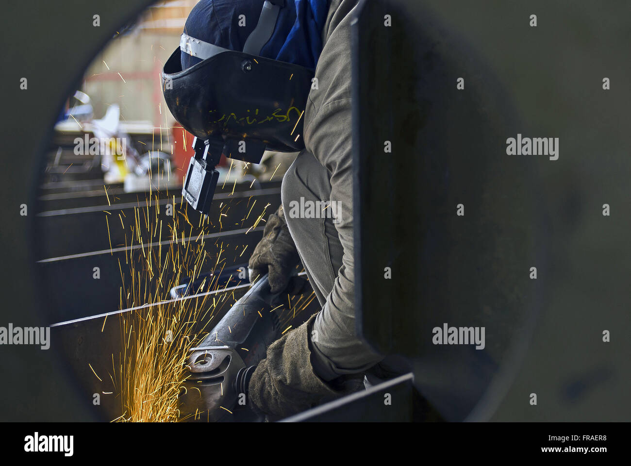Laborer with sander in shipbuilding Stock Photo