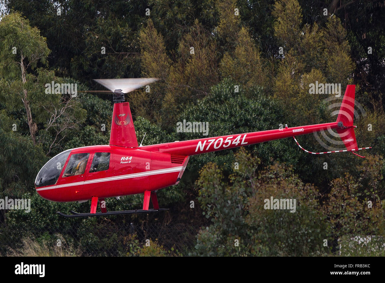 Robinson R44 Raven II (registration N7054L) helicopter flying over Palo Alto Airport (KPAO), Palo Alto, California, United States of America Stock Photo