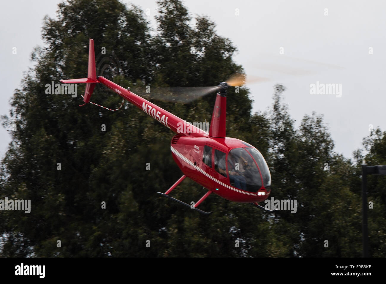 Robinson R44 Raven II (registration N7054L) helicopter flying over Palo Alto Airport (KPAO), Palo Alto, California, United States of America Stock Photo