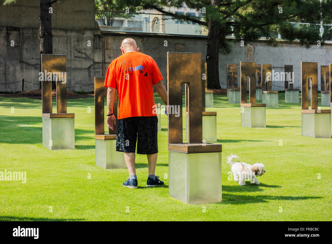 A senior man and his dog walks through the Field of Chairs honoring the victims of the Oklahoma City bombing. Oklahoma, USA. Stock Photo